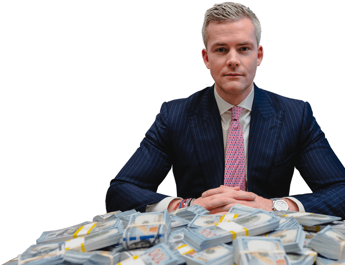 Ryan Serhant sits behind a pile of neat 100-dollar bills.