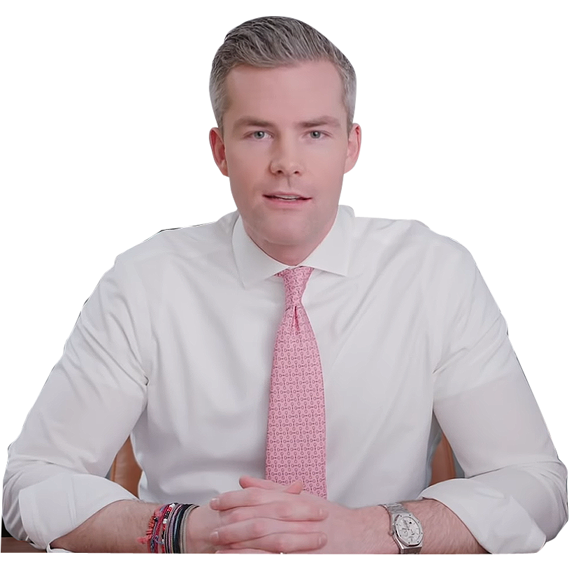 Ryan Serhant in a white shirt with hands folded on a table.