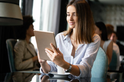 new real estate agent just starting out with tablet in cafe